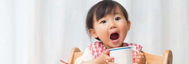 Child eating food and showing teeth