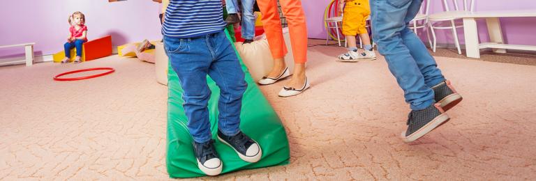 Children running inside in a designated play space.
